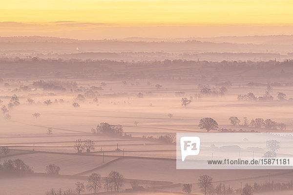 Morgendämmerung über der nebelumhüllten Landschaft der Somerset Levels im Winter  Glastonbury  Somerset  England  Vereinigtes Königreich  Europa