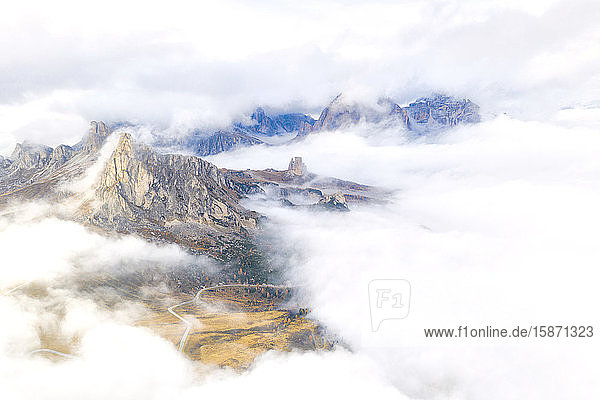 Aerial view by drone of Ra Gusela and Cinque Torri mountains covered by clouds and fog in autumn Giau Pass Dolomites Belluno Veneto Italy Europe