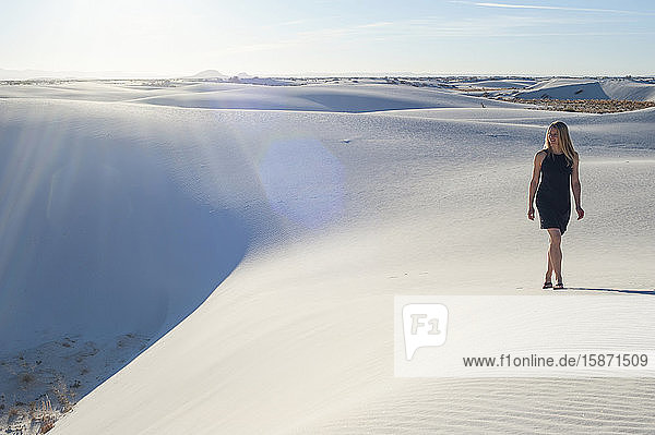 A woman strolls along the ridge of a pure white sand dune in White Sands National Park  New Mexico  United States of America  North America