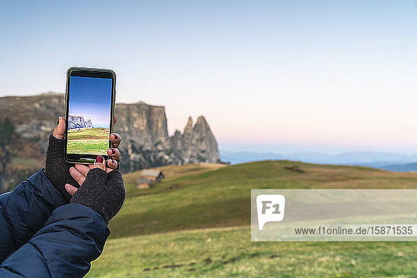 Persönliche Perspektive einer Frau beim Fotografieren von Schlerngipfeln mit Smartphone  Seiser Alm  Dolomiten  Südtirol  Italien  Europa