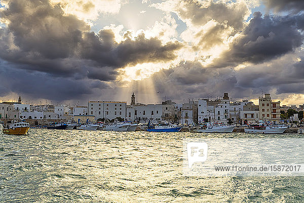 Old town illuminated by sun rays that filters between clouds Monopoli Apulia Italy Europe