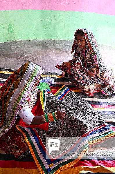 Frauen beim Sticken traditioneller Stammesdecken in ihrem Bhunga (kreisförmiges Dorf-Lehmhaus)  Bhirindiara  Kutch  Gujarat  Indien  Asien