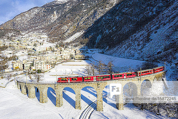 Der Bernina Express fährt über den Spiralviadukt von Brusio  UNESCO-Welterbe  Valposchiavo  Kanton Graubünden  Schweiz  Europa