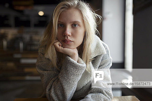 Young woman with wool coat in cafe