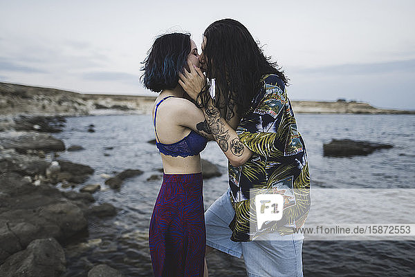 Junges Paar küsst sich am Strand