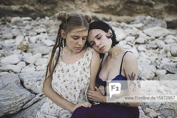 Junge Frauen sitzen zusammen am Strand