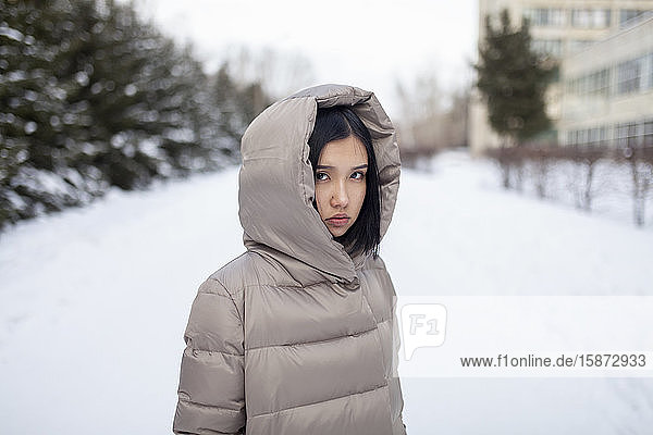 Young woman in hooded jacket during winter