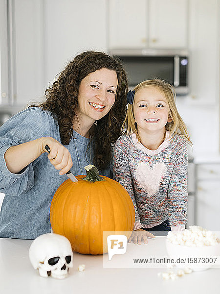 Mother and daughter carving pumpkin for Halloween