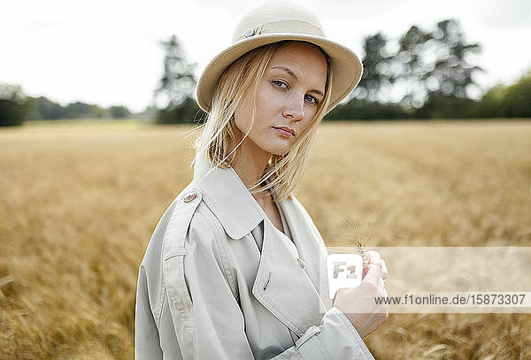 Young woman with fedora in wheat field