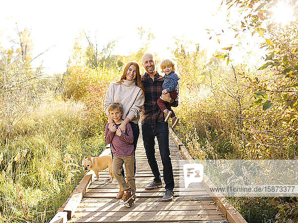 Lächelnde Familie auf der Waldpromenade