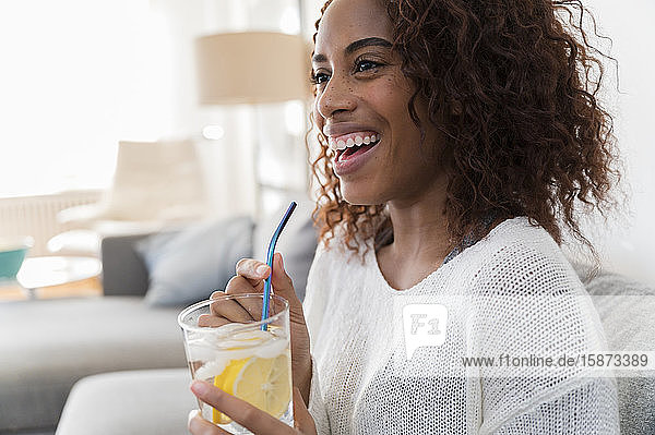 Lächelnde Frau hält Getränk mit Strohhalm