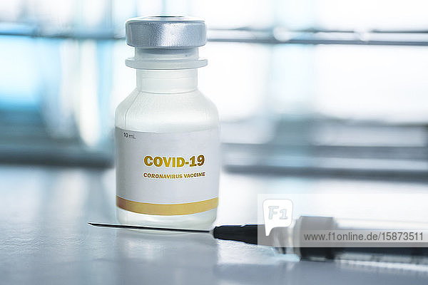 Fläschchen mit Covid-19-Impfstoff und Injektionsnadel
