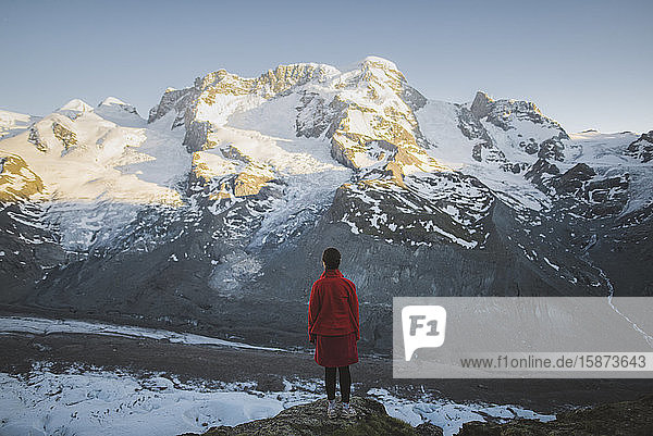 Woman standing on rock by Gorner Glacier in Valais  Switzerland