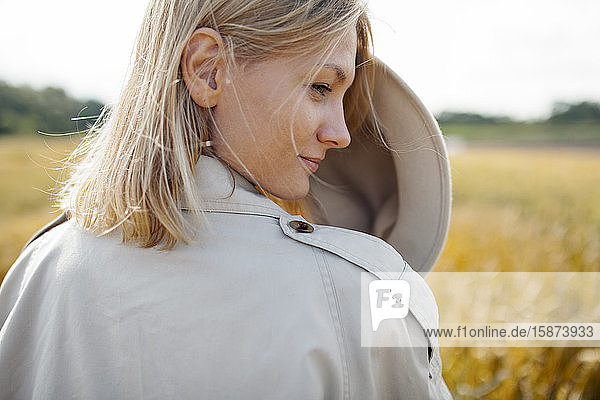 Junge Frau mit Filzhut in einem Weizenfeld