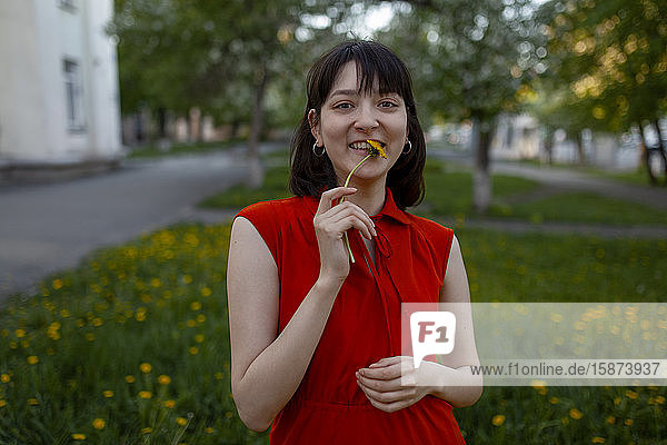 Smiling young woman holding flower