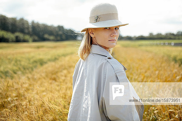 Young woman with fedora in wheat field
