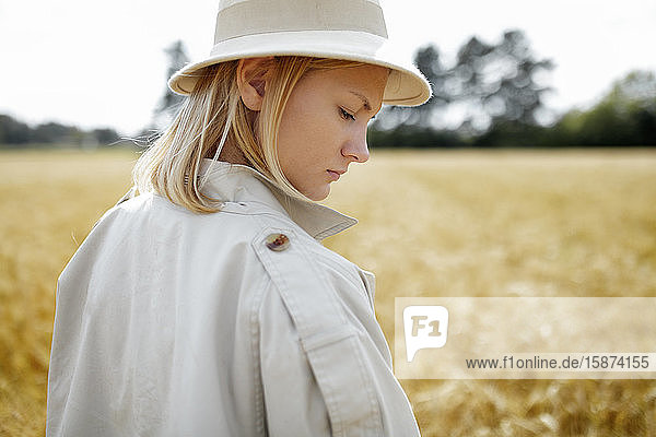 Young woman with fedora in wheat field
