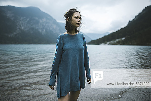 Young woman in blue sweater by lake