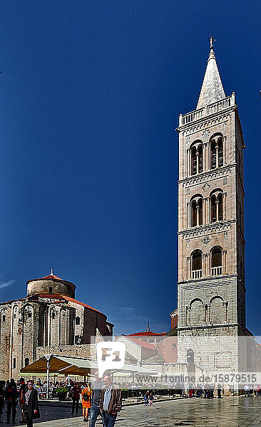 Zadar  Dalmatia province  Croatia  Pedestrians pass towards the Roman Forum  Saint Donat Church and the Cathedral bell tower