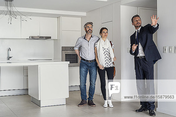 Immobilienmakler zeigt einem Ehepaar sein neues Haus