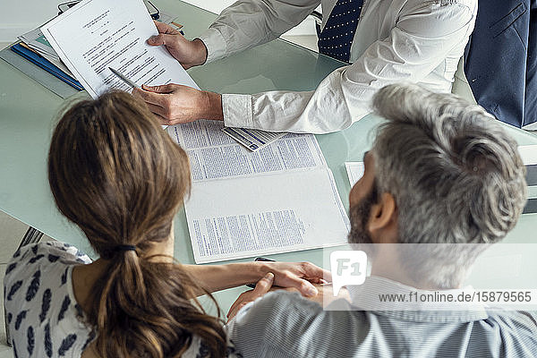 Real estate agent discussing document with couple