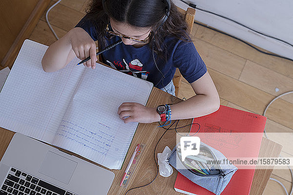 Girl attending online school classes from home