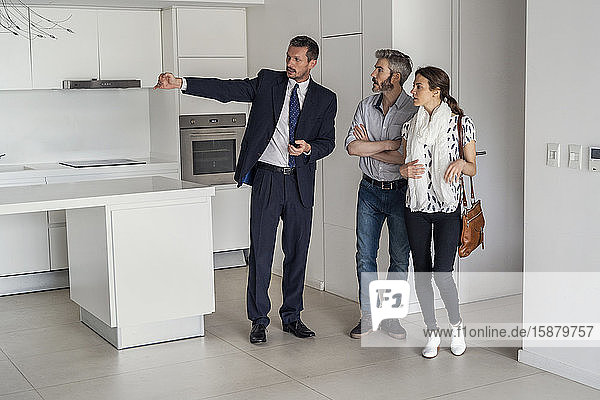Real estate agent showing new house to couple