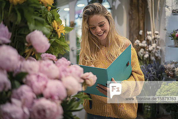 Junge Frau hält Akte in einem Blumenladen