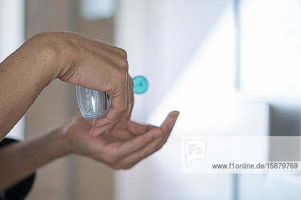 Man's hands applying alcohol sanitizer gel