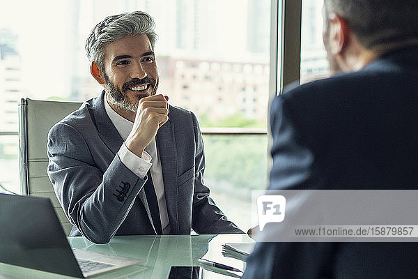 Smiling businessman talking with his colleague