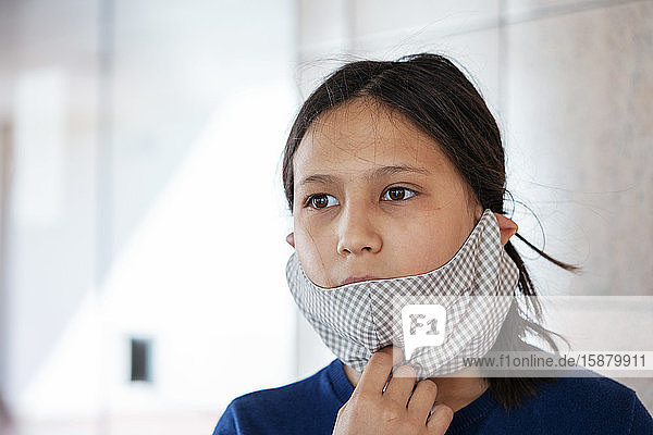 Close up von Teenager-Mädchen trägt hausgemachte Gesichtsmaske drinnen