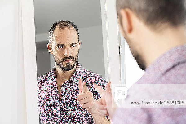 A man looking in a mirror to give him self-confidence.