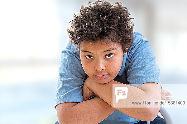 Boy portrait arms crossed enigmatic expression