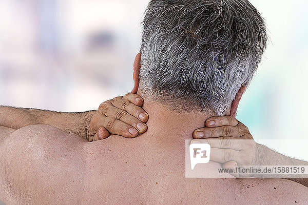 Nackenschmerzen.medizinisches Konzept. Senior Mann berührt Hals  Schmerzen im Nacken  Rückansicht