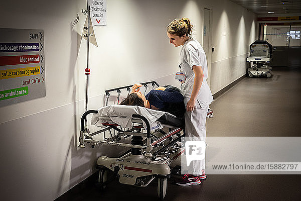Eine Krankenschwester diskutiert mit einer Patientin  bei der sich die Karte in einer Tasche befindet.