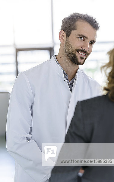 Porträt eines selbstbewussten Arztes bei einem Treffen mit einer Geschäftsfrau im Krankenhaus
