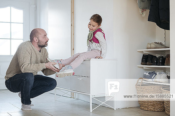 Father and daughter ironing together at home