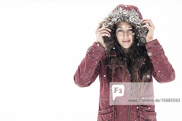 Porträt einer jungen Frau mit Kapuzenjacke im Winter
