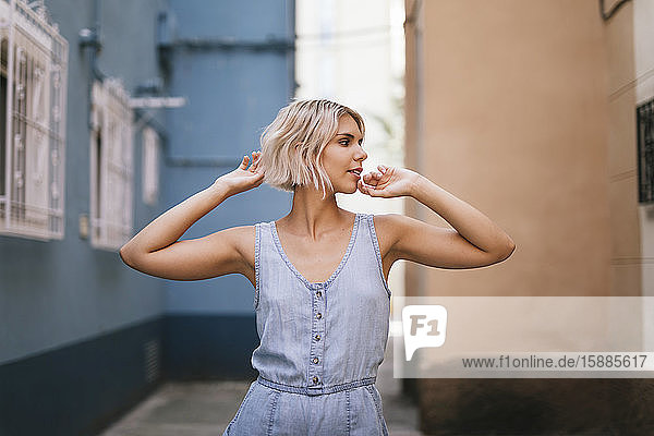 Portrait of young woman wearing light blue overall in the city