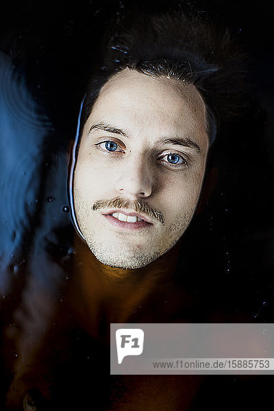 Portrait of young man with blue eyes in water