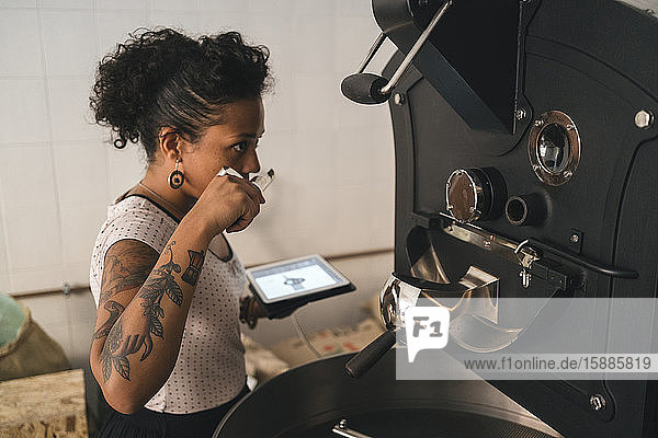 Frau arbeitet in einer Kaffeerösterei und riecht nach Produkt