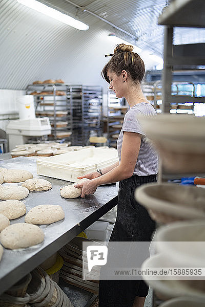 Frau bereitet Brot in Bäckerei zu