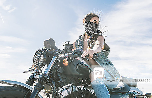 Young beautiful woman riding motorbike