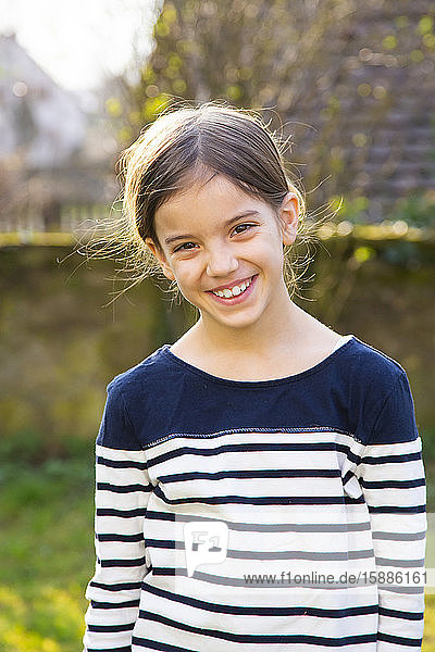 Porträt eines lächelnden Mädchens im Garten
