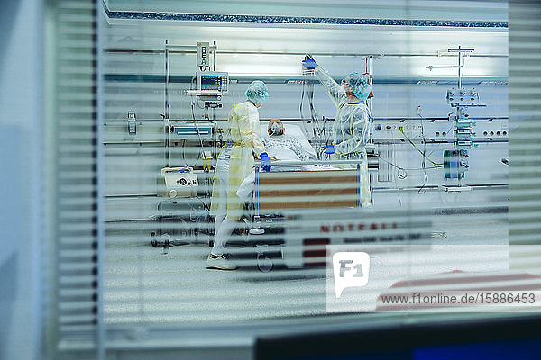 Ärzte hinter Sonnenblende betreuen Patienten auf der Notfallstation eines Krankenhauses mit Beatmungsgeräten
