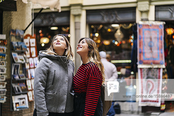 Two young women in the city looking up