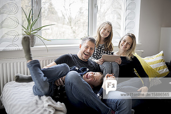 Portrait of happy family having fun on couch at home