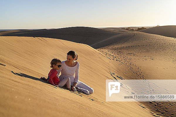 Mutter und Tochter sitzen in Sanddünen  Gran Canaria  Spanien