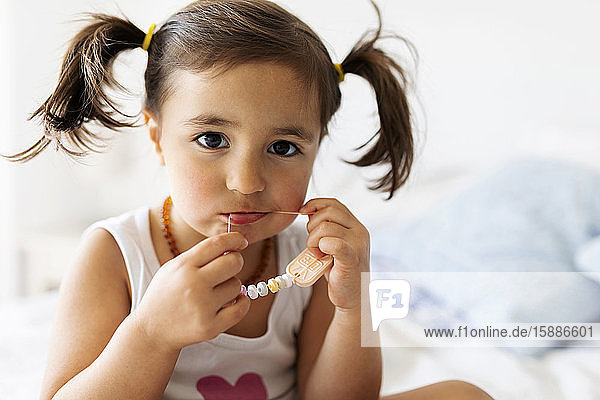 Porträt eines kleinen Mädchens  das Süßigkeiten isst