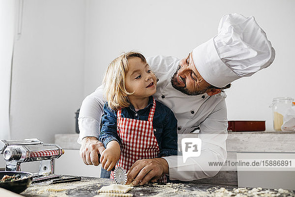 Vater und Tochter schneiden mit dem Nudelschneider selbstgemachte glutenfreie Nudeln